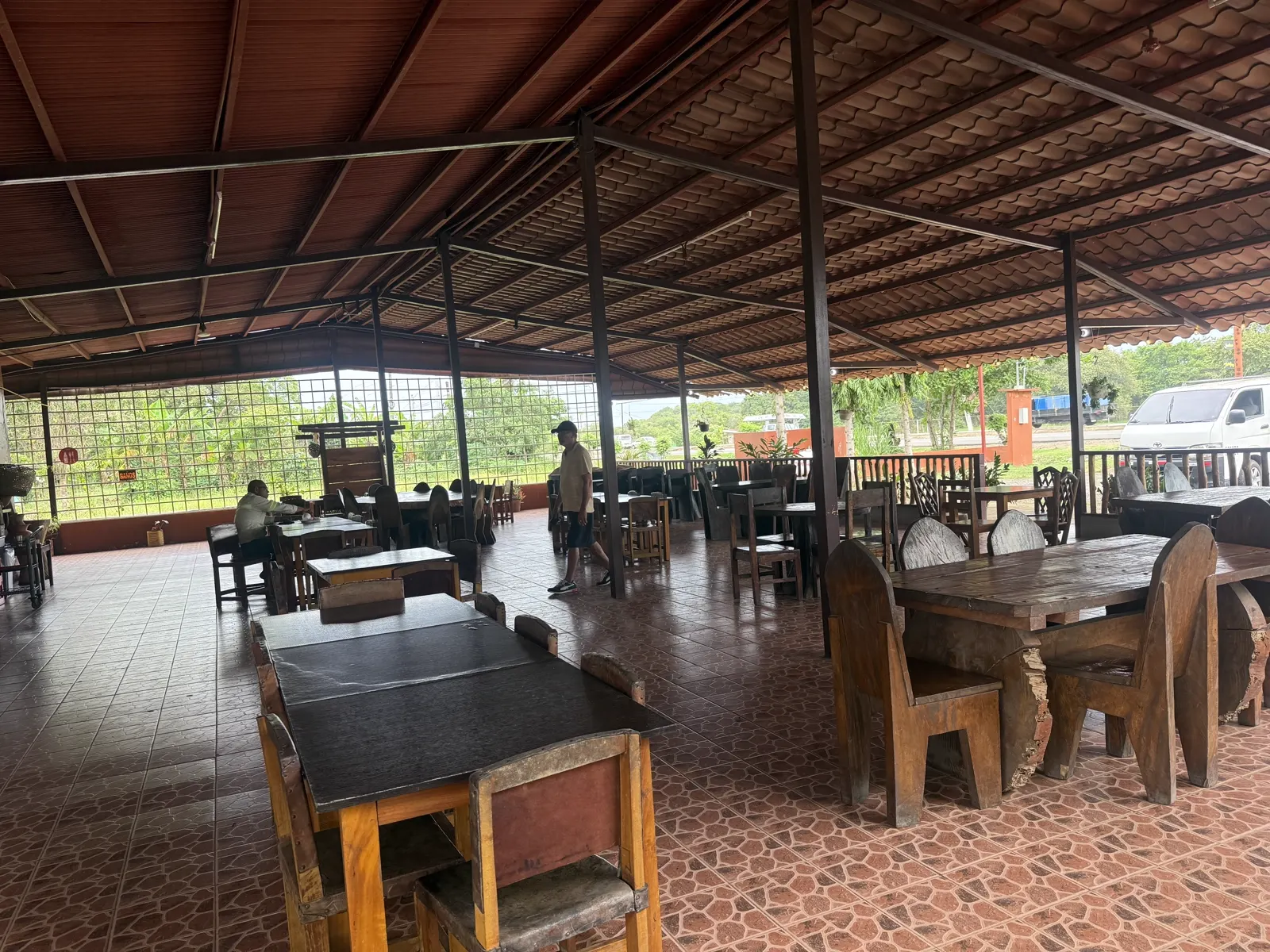 Comedor abierto de El Rancho Interiorano en El Roble, con mesas de madera rústica y piso de terracota
