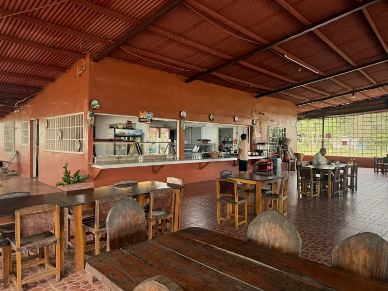 Vista general del comedor con la barra de despacho y mesas de madera