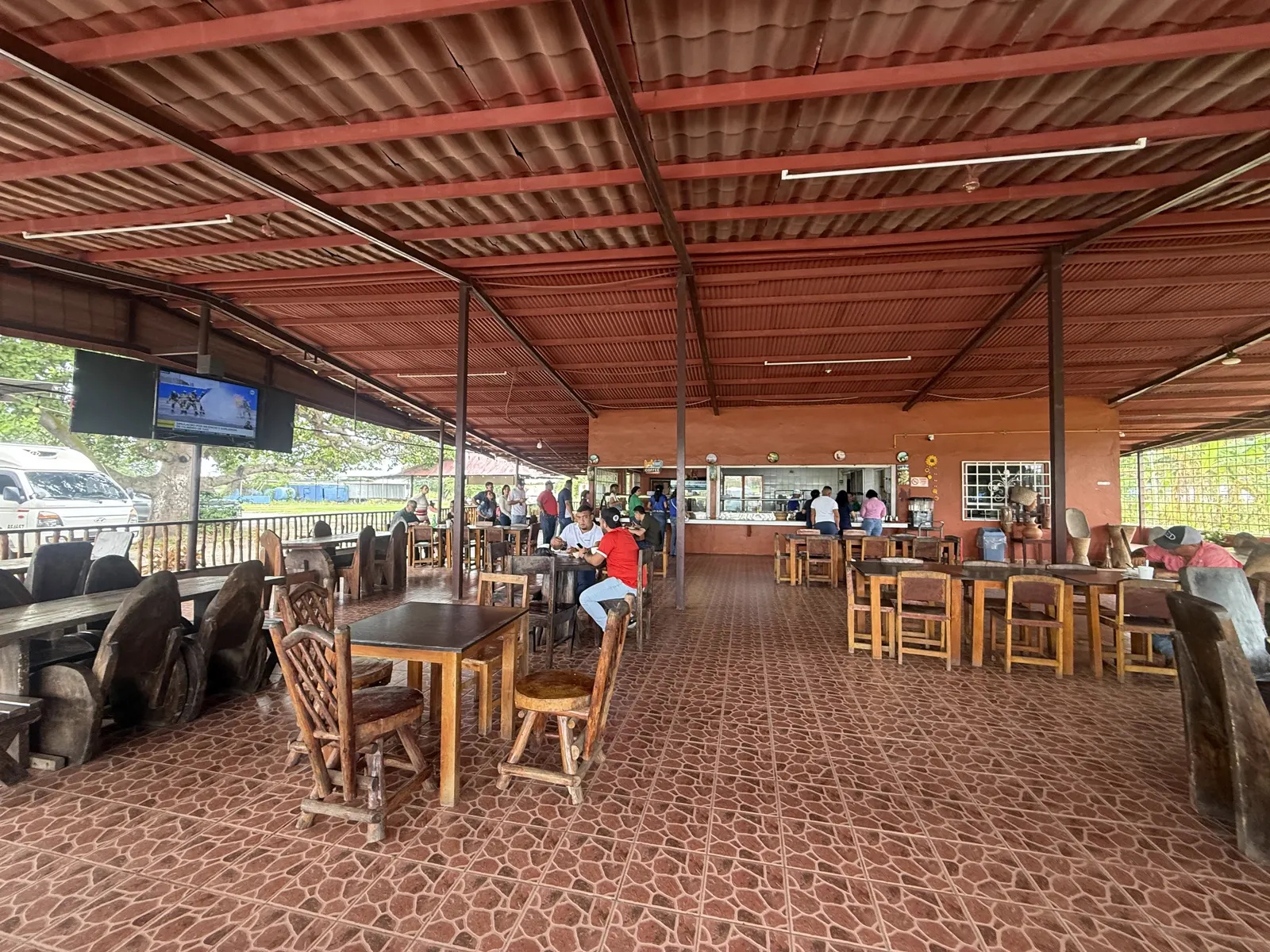 Comedor lleno de comensales con mesas de madera rústica