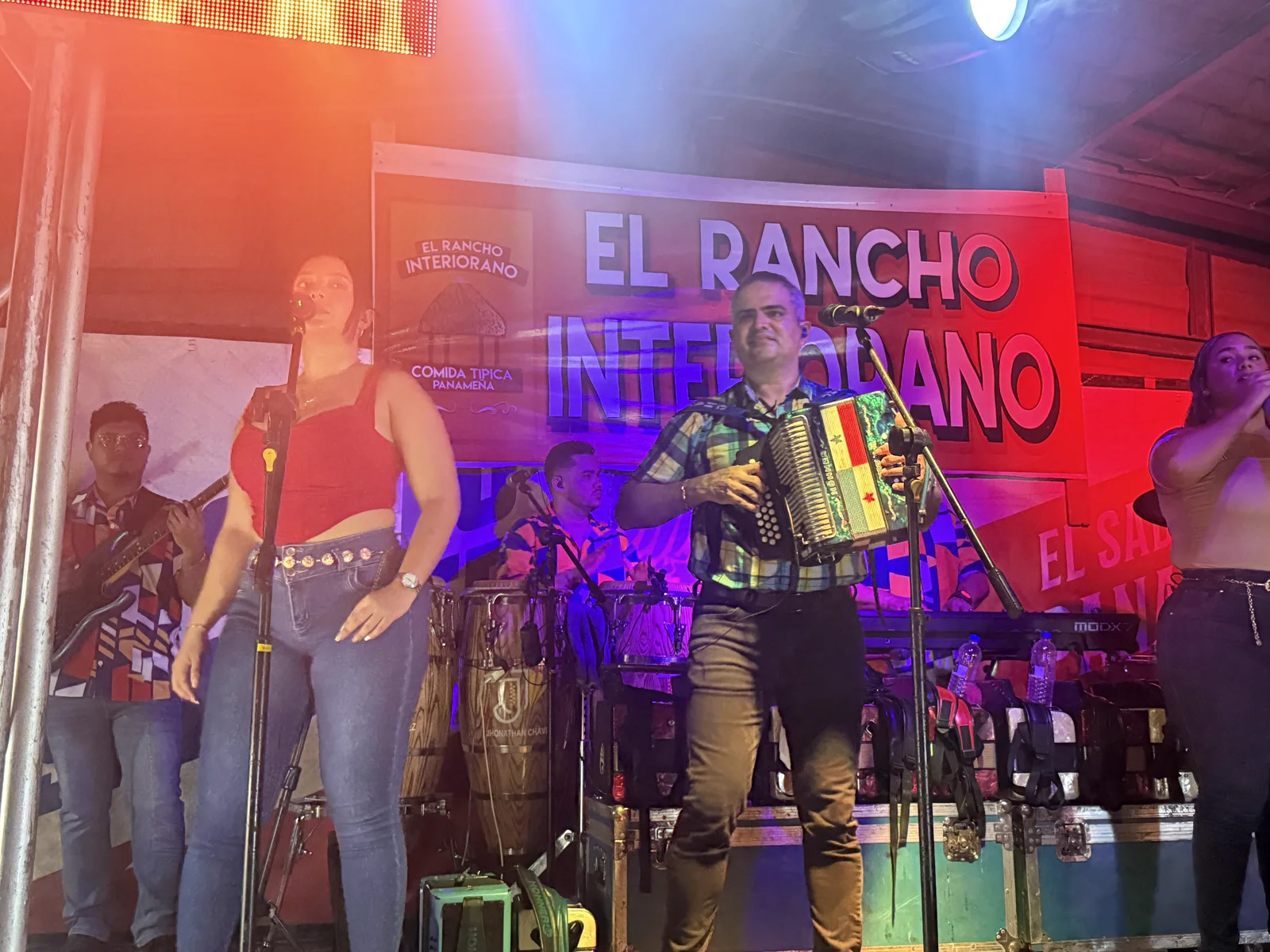 La orquesta de Jhonathan Chávez tocando en la tarima de El Rancho Interiorano, con el banner del negocio detrás