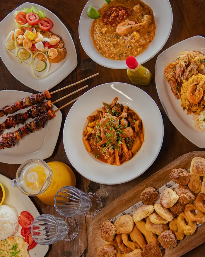 Mesa servida con pinchos, guisado, camarones y hojaldres, mismo plato del menu compartido de El Rancho Interiorano